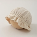 Detaillierte Makroansicht der zarten floralen Spitze und Rüschen am Baby-Sonnenhut - 35-46cm 0-12 Monate / Beige