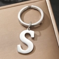 Silver metal alphabet letter S keychain with round ring on golden gift box - S