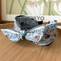 Close-up of paisley pattern satin headband with a central knot on a wooden tray - Bow Headband / Floral Blue