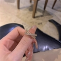 Close-up of a gold criss-cross ring with multiple rows of pavé and baguette diamonds - Gold Cross Zirconia