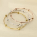 Detailed view of three polished metal bangles in gold, silver, and rose gold with moving beads - Inner Diameter 60mm / 3 Rings / Multicolor