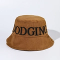 Détail de la broderie noire DODGING sur un chapeau bob en coton caramel pour l'été - Marron