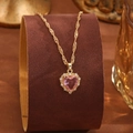 Detail view of heart-shaped pink crystal pendant necklace with small diamonds on gold chain - Pink