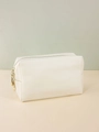Detailed view of white PU leather makeup bag with cross-grain texture and gold zippers - Beige