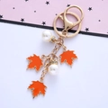 Close-up of maple leaf keychain with orange enamel pendants and rhinestone pearls - Single OPP Bag Packaging / Orange