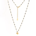 Détail du collier en chaîne dorée avec perles noires, pendentif cœur poli et fermoir - Perle Noire