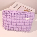 Neceser violeta con textura de burbujas acolchada y etiqueta decorativa de H&R BAG - Morado