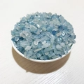 Natural tumbled aquamarine crystal chips in a white ceramic bowl for DIY crafts - Aquamarine