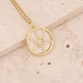Close-up of a gold necklace with a white circular pendant and a zircon star inlay - White (Shell Texture)