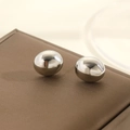 Macro detail of polished silver ball stud earrings with high mirror finish on leather surface - Silver Bean Sphere / Silver