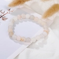 Close-up of natural lava stone bracelet with smooth white and pink marble crystal beads - White Bead