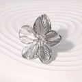 Bague fleur argentée élégante avec pétales texturés sur un socle blanc minimaliste - Couleur Acier