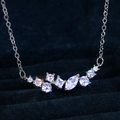 Micro shot of a silver necklace with cluster zircons on dark blue velvet background - White Gold