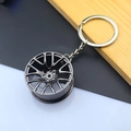 Detailed macro view of a glossy dark grey alloy car wheel rim keychain with a flat metal ring - Wheel Rim / Black