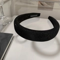 Detail of a handmade thick black headband with sparkling fabric and woven label - Black