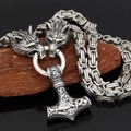 Vue macro du pendentif Mjolnir viking avec têtes de loup sur une chaîne tressée - Collier En Argent