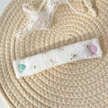 Detailed view of quilted floral fabric cable organizer with heart-shaped buttons - Pink Ditsy Floral