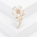 Elegante broche de flor dorada con pétalos de esmalte blanco, cristal y una perla - Dorado