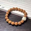 Brown carved bodhi seed bracelet with white cat paw charm on wooden table - Vajra (Lion Dance)