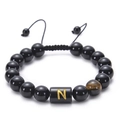 Detailed macro of obsidian beaded bracelet with tiger eye stone and letter N charm - Letter N