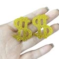 Orecchini a segno di dollaro dorati in acrilico con glitter tenuti in mano su sfondo bianco - Stile orecchino a bottone oro