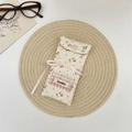 Detailed shot of floral fabric eyewear pouch with pink bow and lace pattern patchwork - Beige