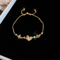 Detailed view of gold heart slider bracelet with LOVE engraving and pavé zircon stones - Gold Heart