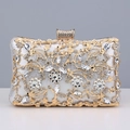 Close-up of silver evening clutch featuring intricate gold floral hollow patterns and rhinestones - Silver