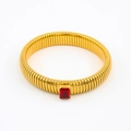 Macro detail of gold-plated ribbed bangle with a rectangular red zircon stone setting - 10mmx18cm / Black Zirconia