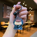 Détail d'un porte-clés à paillettes bleues avec personnage de dessin animé et cloche noire - Style Mousqueton / Matériel Noir Perle de Bulle Lumineuse Sœur Fruits
