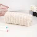 Detailopname van een pluchen cilindrische etui in crème beige met zachte textuur - Beige