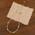 Detail of elegant pearl necklace with gold metal tubes on rustic handmade paper - Bright Pearl Gold Necklace
