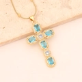 Detail of 18K gold cross necklace featuring blue rectangular stones and white zircons - Lake Blue