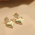 Détail de boucles d'oreilles cœur dorées avec pavé scintillant et fini poli - Coeur Poli