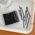 Detailansicht der 5,5cm schwarzen gewellten Haarklammern in Großpackung auf Tablett - 1# Wellige Haarklammern 100 Stk.