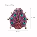 Spilla a forma di coccinella con cristalli e dimensioni 3,3cm x 3,3cm su sfondo bianco - Coccinella con Strass Multicolore