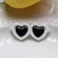 Dettaglio di mini occhiali da sole a cuore bianchi su un piatto di ceramica - Piccolo 2.9x1.2cm / Bianco
