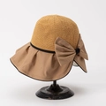 Dettaglio di un cappello da sole estivo in paglia con un grande fiocco decorativo - M (56-58cm) / Cachi