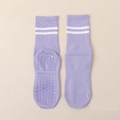 Detail of purple yoga socks featuring anti-slip grippers and white athletic stripes - One Size / Purple
