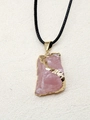 Détail macro du pendentif en cristal rose naturel avec bords dorés et cordon noir tressé - Quartz rose