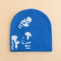Blue knitted beanie with white abstract pattern on a neutral beige background - Blue