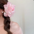 Seitenansicht eines Modells mit einer großen rosa Netzblumen-Haarspange in geflochtenem Haar - Gaze-Rosen-Stil / Rosa