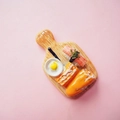 Dettaglio di un magnete alimentare in resina con tagliere in miniatura e decorazione pane - Vassoio Pane / Senza Calamita