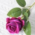 Single deep purple artificial velvet rose with green leaves on white knit background - Rose Purple (Velvet Version)