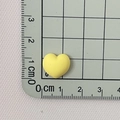 Mini yellow matte resin heart charm for DIY crafts and jewelry on measuring mat - Yellow