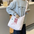 Pink quilted tote bag with puppy embroidery shown on a model in a bright kitchen - Pink Quilted Bag with Running Puppy Embroidery