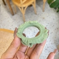 Detail of green ruffle fabric scrunchie showing pleated texture held in hand - Grass Green