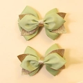 Detailed close-up of green and gold glitter bow hair clips for kids on beige background - Grass Green