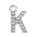 Macro shot of silver letter K pendant with sparkling white rhinestones for DIY jewelry - Letter K