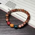 Chinese black rosewood bracelet with square beads and colorful spacer beads on a book - 7mm Three-Color Cube Beads